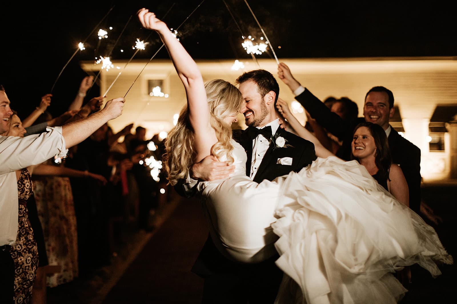 Bride and groom sparkler exit surrounded by cheering guests